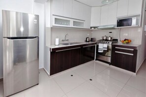 Een koelkast/vriezer, een magnetron, een oven, een kookplaat