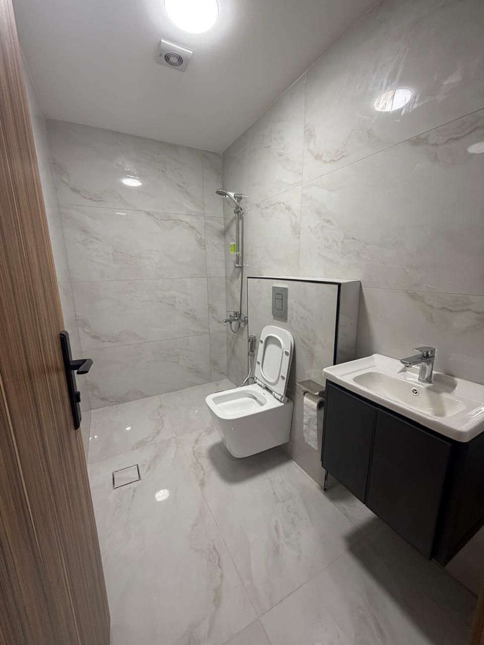 Ein modernes Badezimmer mit Toilette, Dusche und Waschbecken.