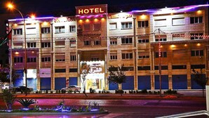 A hotel with multiple floors, a prominent 'HOTEL' sign, and a storefront with a sign in a foreign language. - Skylight Apartments (Amman)