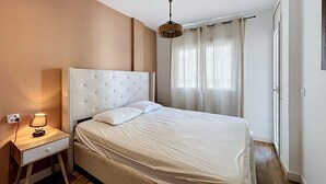 Ein Schlafzimmer mit einem Bett, einem Nachttisch, einer Lampe und einer Pendelleuchte.