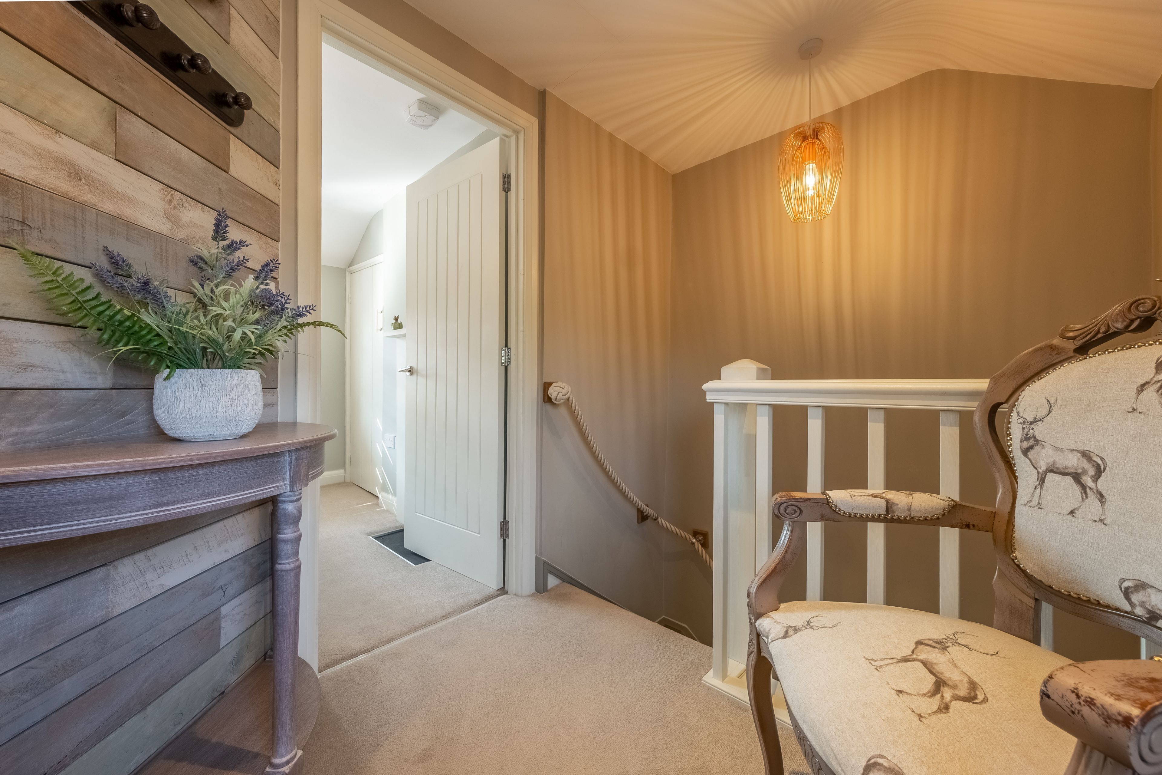 A staircase with a wooden railing and a chair with a deer pattern.