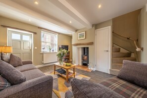 A cozy living room with a fireplace, a sofa set, and a staircase. - Sandpiper's Cottage, South Creake, Norfolk (South Creake)