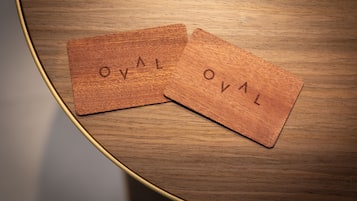 Dos baldosas de madera con la inscripción "TVO" sobre una mesa redonda de madera.
