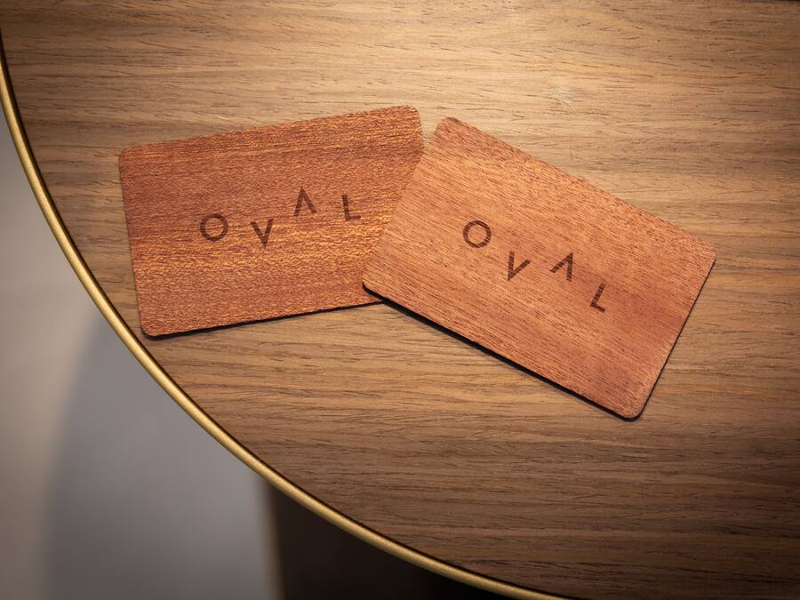 Dos baldosas de madera con la inscripción "TVO" sobre una mesa redonda de madera.