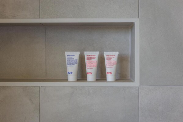 Three tubes of lotion on a shelf.