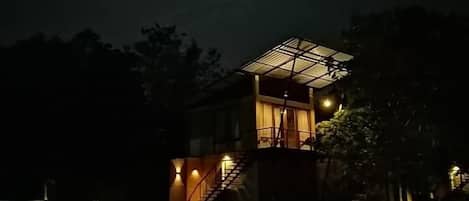 A building with a pool at night, under a full moon.