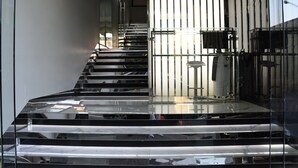 Un escalier moderne aux surfaces réfléchissantes et aux rampes en métal.