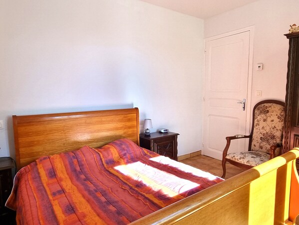 A bedroom with a wooden bed, a nightstand, a chair, and a door. - House for 4 people with terrace near the port in Port-Vendres (Port-Vendres)