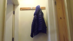 A hallway with a coat rack and a shoe rack. - Light and Airy 1 bed Flat With Large Basement Kitchen and Private Outside Area (leeds)