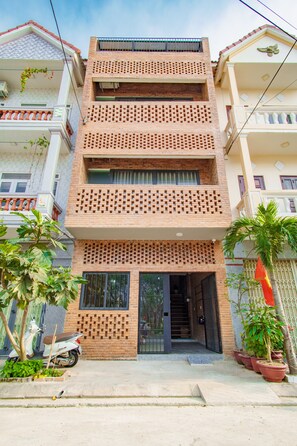 Stylish residential building with a brick facade and balconies on upper floors.