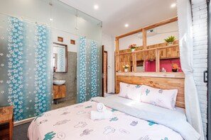 Relax in a serene space with a plush bed, large mirror, and sliding door to the bathroom.