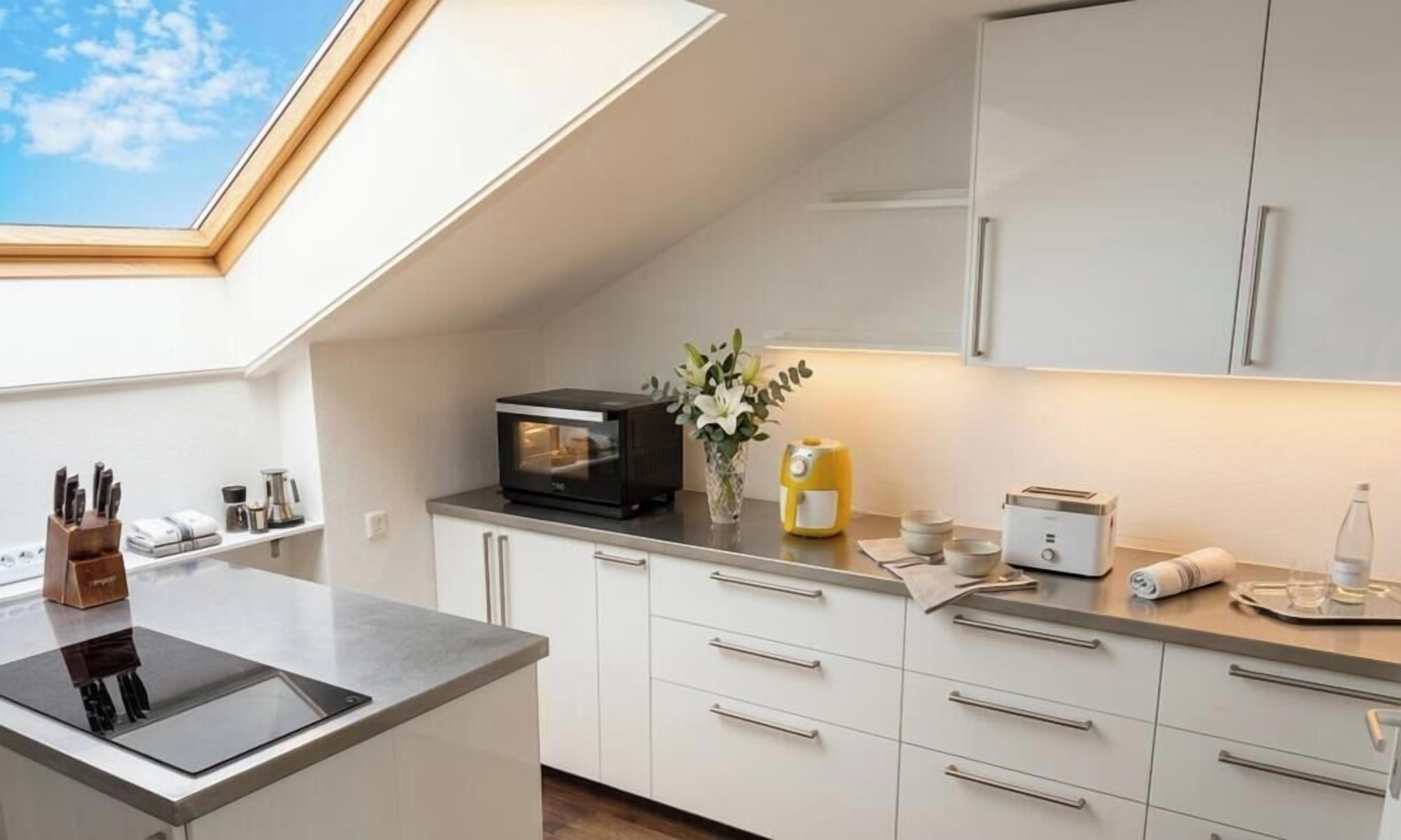 A modern kitchen with a skylight, a microwave, a toaster, and a sink.