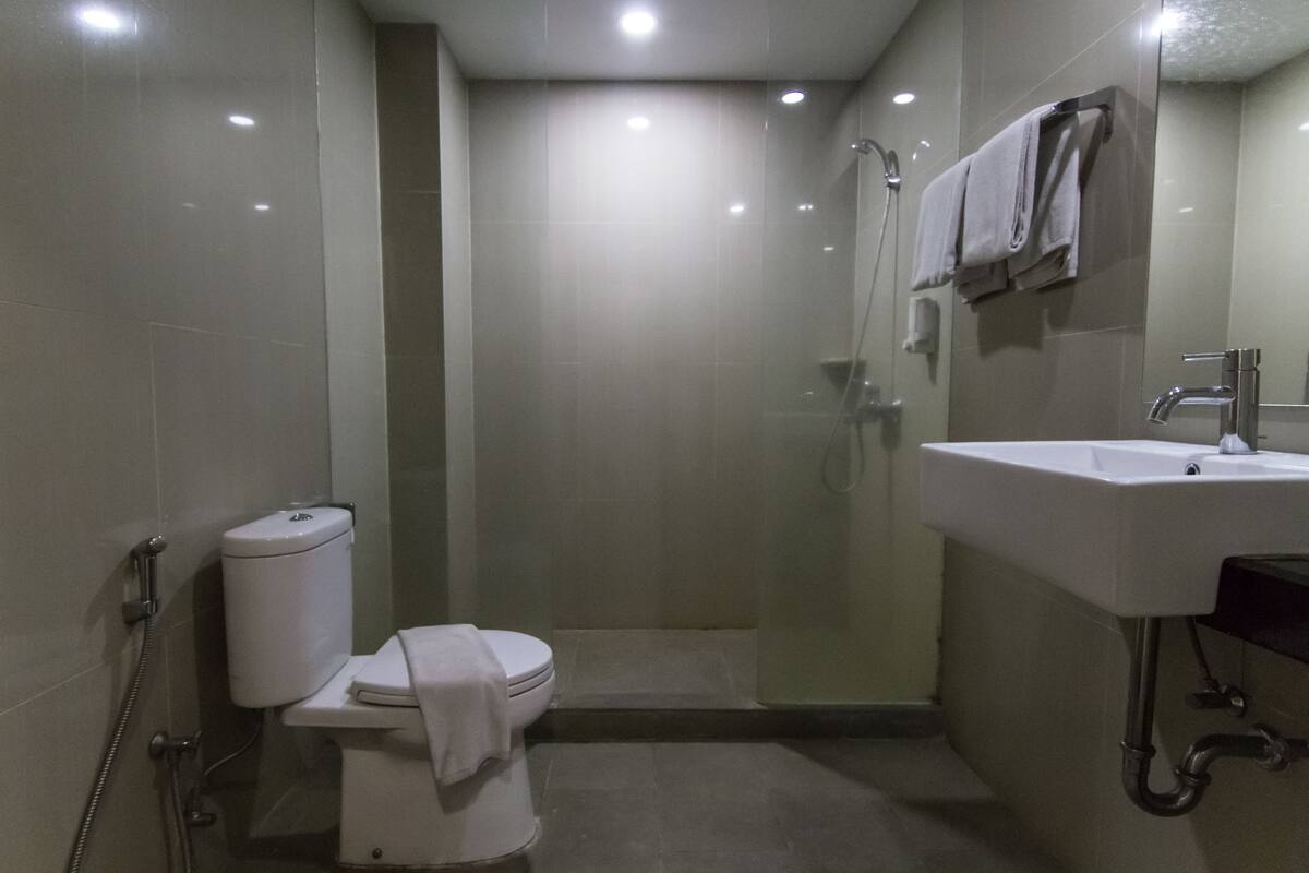 Une salle de bain comprenant des toilettes, une douche et un lavabo.