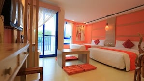 Habitación de hotel con dos camas, un escritorio de madera, televisión y un ventanal grande.