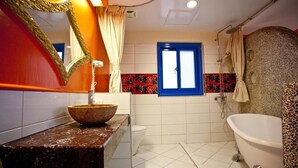 Un baño con lavamanos de mármol, bañera y ducha.