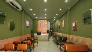 A restaurant with green walls, multiple seating areas, and a counter at the end. - SAZI AMILA Nguyen Hue HOTEL - Free Banh Mi (Ho Chi Minh City)