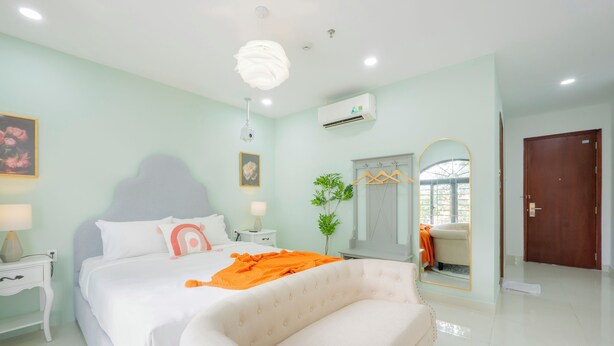 A bedroom with a large bed, a bedside table, a nightstand, a mirror, a door, and a window. - SAZI AMILA Nguyen Hue HOTEL - Free Banh Mi (Ho Chi Minh City)
