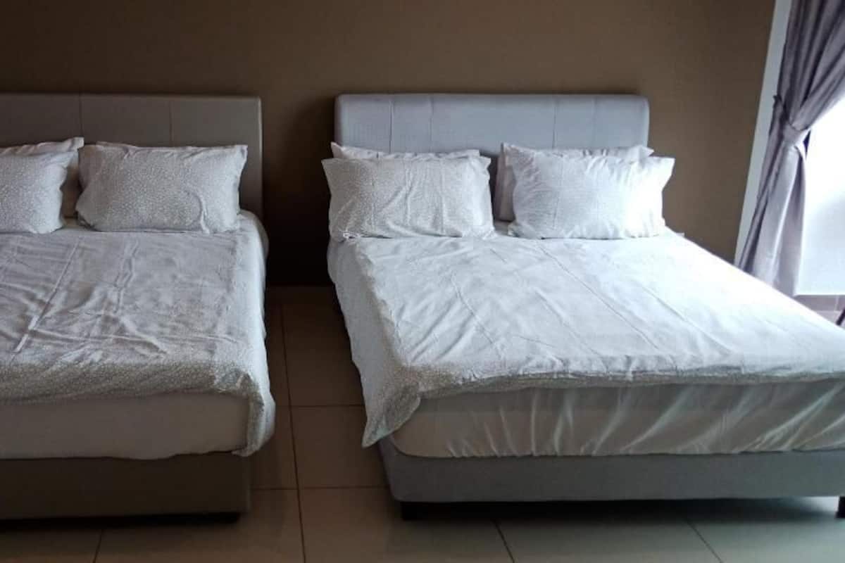 Two twin beds with headboards, white bedding, and a neutral color scheme.