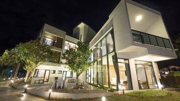 Experience the sleek, modern design of this contemporary building, featuring large windows and an inviting outdoor seating area.
