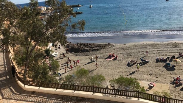 A beach with people sunbathing and swimming, a clear sky, and boats in the water. - Air-conditioned 2 bedroom villa in Orihuela Costa with pool and sea 1 km (Orihuela Costa)