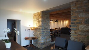 A cozy dining area with stone walls, wooden furniture, and pendant lighting. - The ash trees of Augustus (Clavières)