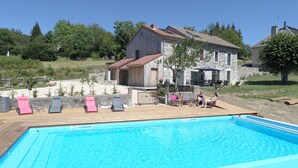 A swimming pool with lounge chairs, a stone building with a tiled roof, and a grassy area with trees. - The ash trees of Augustus (Clavières)