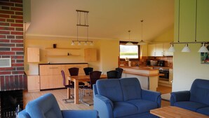 Ein modernes Wohnzimmer mit blauen Sofas, einem Holztisch und einem Kamin.