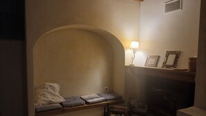 A cozy room with a built-in bench, a small table, a lamp, and a fireplace. - Mansion - Souvignargues (Souvignargues)