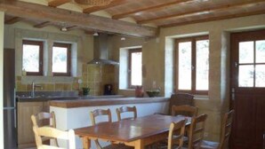 A kitchen with wooden beams, a dining table with chairs, and a large window. - Mansion - Souvignargues (Souvignargues)