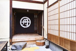 Una entrada tradicional japonesa con puerta de madera y un panel corredero.