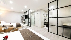 Habitación de hotel con cama, escritorio, silla, televisor y armario.