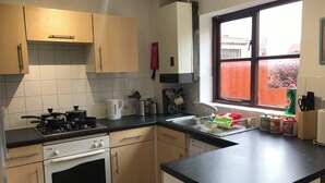A kitchen with a stove, oven, sink, and window. - Swale Corner Home from Home (Wellingborough)