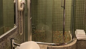 A bathroom with a glass-enclosed shower, a white sink, and a mirror. - Peanut House (Hengchun)