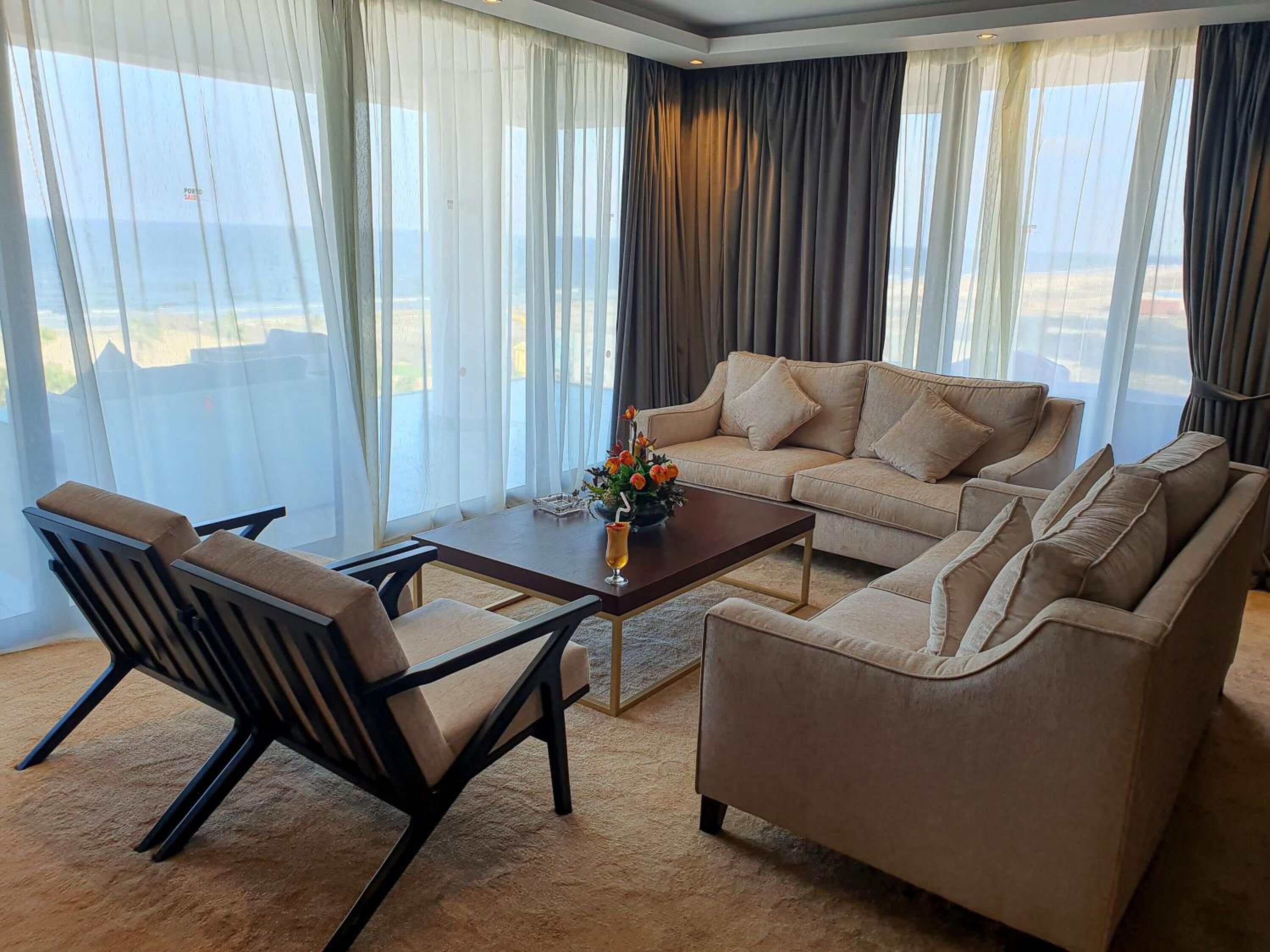 A modern living room with a sofa, armchairs, and a coffee table.