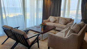 A modern living room with a sofa, armchairs, and a coffee table.