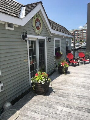 A building with a sign reading "GREEN TURTLE" and a dock with red chairs.