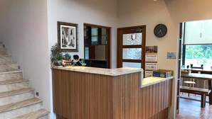 A reception area with a wooden counter, a clock, and a calendar on the wall. - Jt158 B&B (Hengchun)