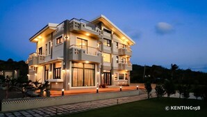 A multi-story modern building with balconies and large windows, surrounded by a well-maintained garden. - Jt158 B&B (Hengchun)