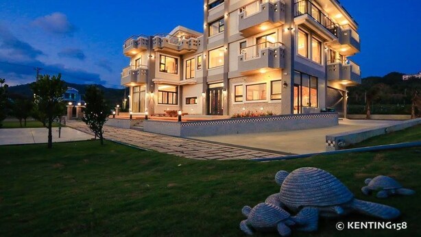 A multi-story building with balconies, a landscaped garden, and a paved driveway. - Jt158 B&B (Hengchun)