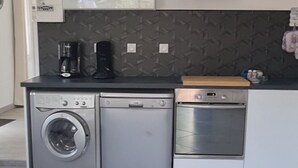 Een moderne keuken met een wasmachine, vaatwasser en een magnetron.