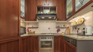 A kitchen with wooden cabinets, a stainless steel oven, a dishwasher, and a microwave.
