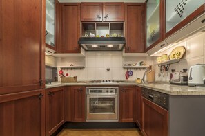 A kitchen with wooden cabinets, a stainless steel oven, a dishwasher, and a microwave.