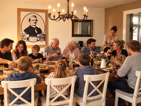 A family dining room with a chandelier, a framed portrait, and a dining table set for a meal.