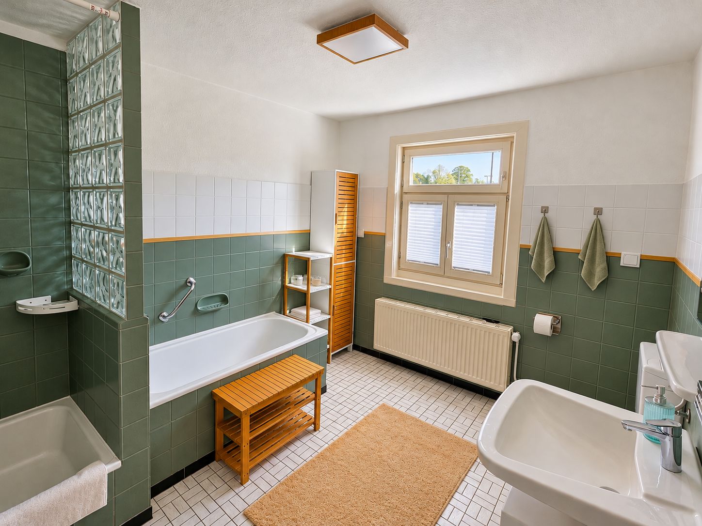 A bathroom with a bathtub, a sink, a window, and a towel rack.