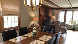 A dining area with a wooden table, black leather chairs, and a chandelier. - ENDLESS VIEWS & Newly Updated!! (York)