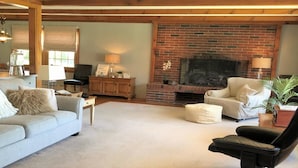 A cozy living room with a brick fireplace, a sofa, a chair, and a lamp. - ENDLESS VIEWS & Newly Updated!! (York)