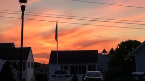 A residential street with houses, a street lamp, and power lines during sunset. - ENDLESS VIEWS & Newly Updated!! (York)