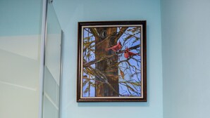 A bathroom with a white toilet, a glass shower enclosure, and a framed painting of birds on a tree. - Whitehall Cottages Boutique Motel - Full Beds (Whitehall)