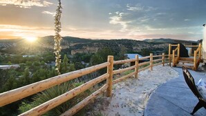 A wooden fence, a bench, and a view of a valley with a building in the distance. - Glamping Yurt near Zion with Sunset Views (Orderville)