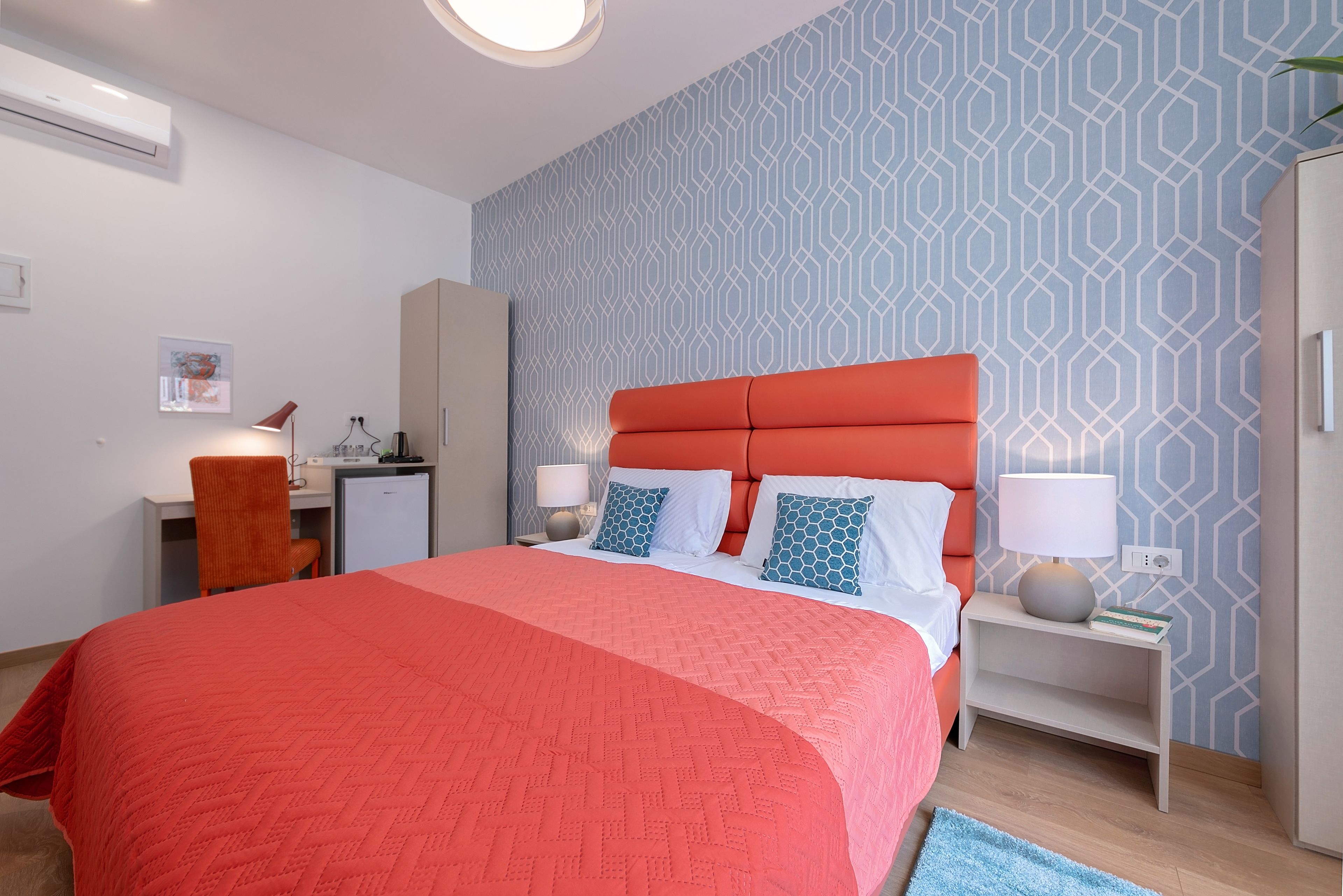 Ein modernes Hotelzimmer mit einem großen Bett, einem Schreibtisch und einem Sessel.